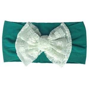 Detail of dark green elastic baby headband featuring a white lace bow in a vintage style