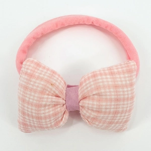 Detailed view of baby nylon headband featuring a large pink and white checkered bow