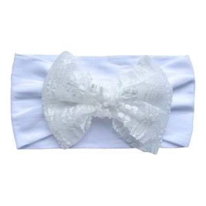 Close-up of white baby headband with soft elastic nylon fabric and delicate lace bow detail