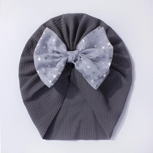 Detailed texture of dark grey baby turban hat featuring a large grey bird print bow