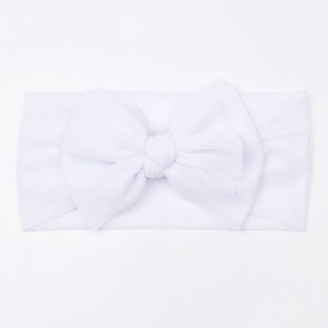 Macro shot of breathable white mesh fabric and oversized bow on soft baby headband