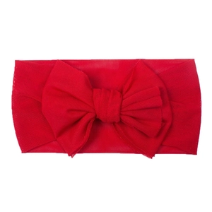 Detail shot of bright red mesh baby headband with a large decorative bow on white background