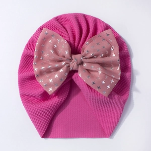 Pink waffle knit baby turban hat featuring a large silver star print bow accessory
