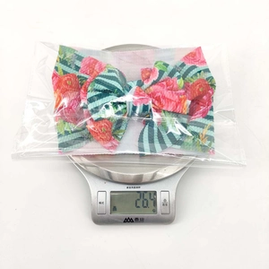 Gewichtskontrolle zeigt florales Baby-Stirnband auf Küchenwaage mit 26,4 g