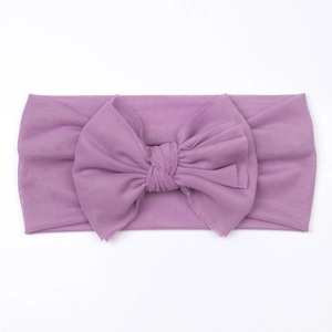Close-up detail of soft purple mesh baby headband with a large bow for infants