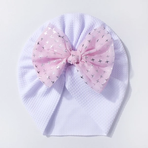 Close-up of baby turban hat featuring waffle knit fabric and a large pink starry tulle bow