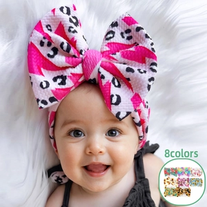 Detail eines Baby-Stirnbandes mit Schleife aus Waffelstrick in Rosa-Blitz-Print