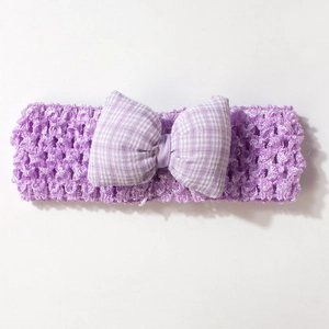Détail du bandeau crochet lilas pour bébé avec un nœud à carreaux violets et blancs