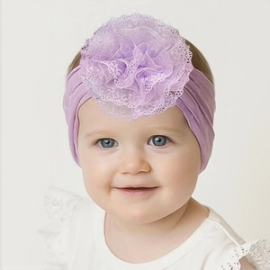 Detail eines lila Baby-Stirnbandes mit einer großen, weichen, mehrlagigen Spitzenblume