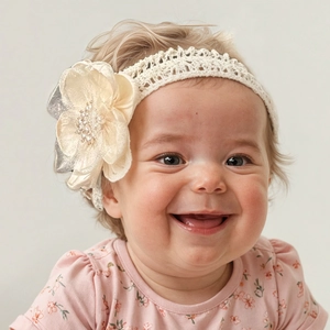 Détail du bandeau en dentelle pour bébé avec grande fleur champagne et perles