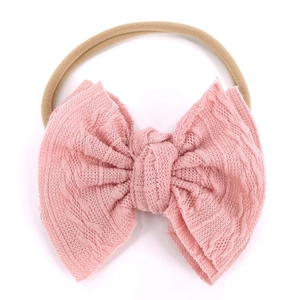 Détail du bandeau bébé avec nœud tricoté rose et bande en nylon souple haute élasticité