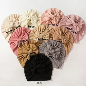 Détail de la texture gaufrée des bonnets turbans pour bébé avec grands nœuds décoratifs