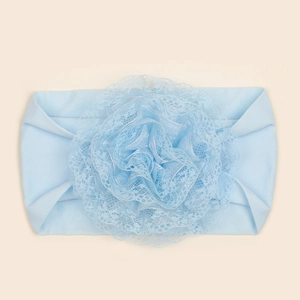 Detail van zachte lichtblauwe babyhoofdband met gelaagde kanten bloemtextuur