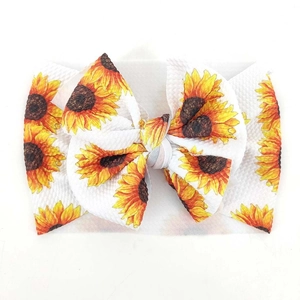 Detail von Baby-Stirnband mit großer Schleife und Sonnenblumenprint auf Waffel-Struktur