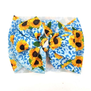Detailansicht Baby-Stirnband mit Sonnenblumen- und Leopardenmuster auf Rippenstrick