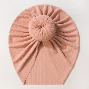 Detail of baby donut turban hat in soft pink ribbed knit fabric with top knot design