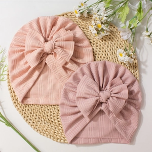 Bonnets bébé en maille côtelée avec de grands nœuds en rose clair et rose poudré