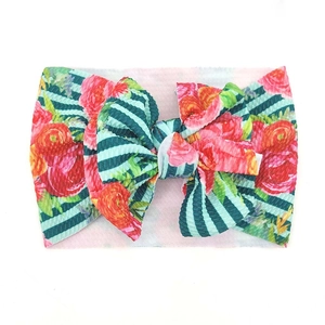 Detail eines Baby-Stirnbandes mit Blumenmuster aus Waffelstoff und rosa Rosen