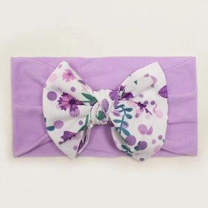 Detail of lavender baby nylon headband featuring a large floral print ribbed bow