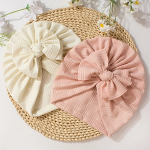 Bonnets turban mignons pour bébé avec texture côtelée et grand nœud en rose et crème
