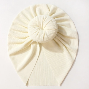 Close-up of cream white donut bun turban hat featuring elastic ribbed knit texture for babies