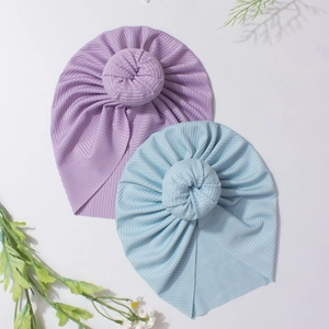 Détail des bonnets bébé donut en violet clair et bleu avec texture en tricot