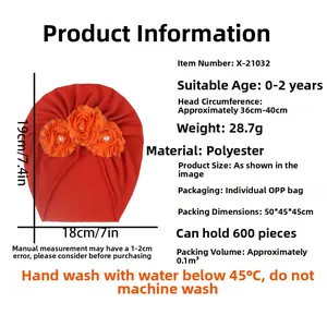 Détail du turban rouge pour bébé avec trois fleurs en tulle orange et perles