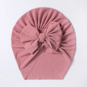 Gros plan d'un bonnet turban rose pour bébé avec un grand nœud décoratif élégant