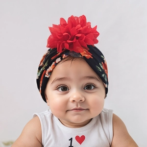 Detail of baby floral turban featuring a large 3D red fabric flower and colorful prints