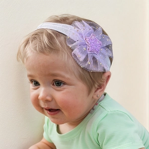 Detail of baby girl headband with purple tulle flower and glitter star on soft band