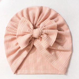 Détail du bonnet turban rose pour bébé avec texture côtelée et grand nœud décoratif doux