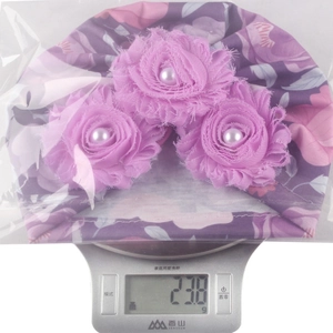 Detail showing baby floral turban weight of 23.8g on a scale for shipping precision