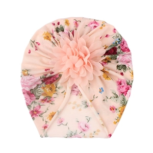 Close-up of soft pink baby turban hat featuring floral prints and a 3D chiffon flower