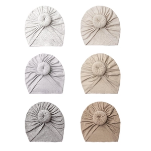 Set of six baby donut beanies in assorted colors made from soft breathable cotton fabric