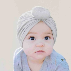 Macro detail of the grey baby turban hat showing donut knot design and soft fabric texture