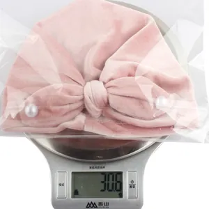 Pink velvet baby turban hat featuring large bow with pearls, weighing approx 30.6g