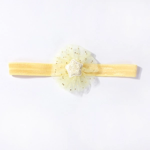 Detailed view of yellow baby headband with mesh floral star and golden sequins