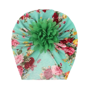Detail view of mint green baby turban featuring pink rose print and 3D mesh flower