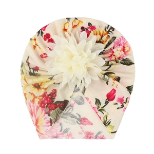Detail of baby floral turban hat with large 3D cream flower and colorful flower print
