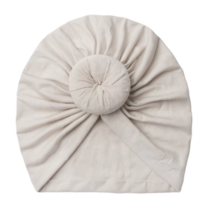 Minimalist ribbed knit baby turban hat with donut knot in soft off-white color