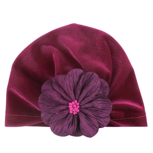 Deep burgundy velvet baby turban hat featuring a large purple fabric flower accent