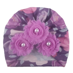 Detail of purple floral baby turban with three fabric flowers and faux pearl centers