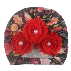 Detail of baby floral turban hat featuring three red 3D flowers with pearl centers