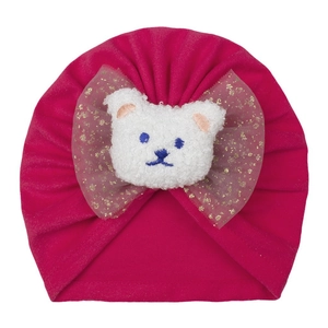 Détail du bonnet rose pour bébé avec un ours en peluche blanc et un nœud doré