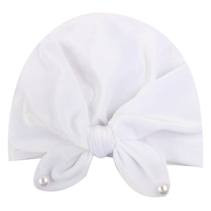 Detail of soft white baby turban hat featuring a large velvet bow and pearl beads