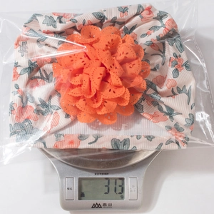 Bonnet floral léger pour bébé pesant 31,3 g sur une balance pour l'assurance qualité
