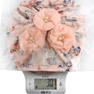 Bonnet turban bébé fleuri rose avec grandes fleurs en mousseline pesant 30,1g sur balance