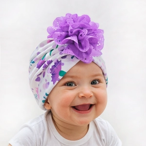 Gros plan sur bonnet turban pour bébé avec un grand ornement de fleur violette