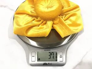 Detail showing 37.1g weight of yellow velvet baby turban on a digital scale