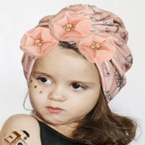 Détail du turban rose pour bébé avec fleurs en mousseline, perles et strass brillants